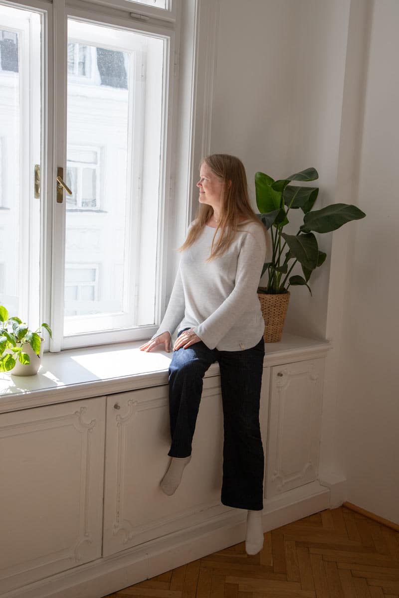 Ingrid Otepka sitzt am Fenster mit Blick in die Ferne